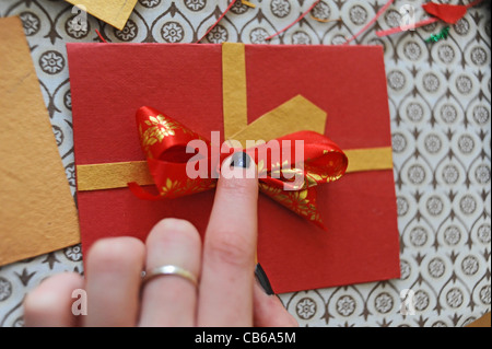 Fare le schede di Natale a mano usando le vecchie schede riciclate dagli anni precedenti Foto Stock