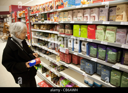 Donna anziana, signora matura di 80s anni, acquisto di farina in un corridoio supermercato, Regno Unito Foto Stock