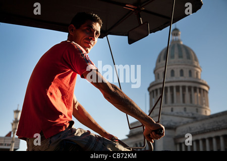 La vita di strada, un 'Bicitaxi' driver nella parte anteriore del Capitolio, Havana (La Habana, Cuba Foto Stock