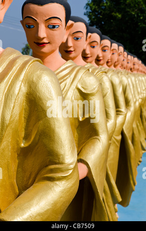 Una linea di vita dimensioni statue di Buddha devoti nelle vesti di oro sono allineate in una fila a Tachileik Shwe Dagon Pagoda in Myanmar Foto Stock