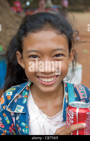 Sorridere i giovani cambogiani ragazza vendita di lattine di coca cola in un villaggio di festa, Cambogiano nuovo anno (Chaul Chnam Thmey), Bakong Village, Siem Reap, Cambogia Foto Stock