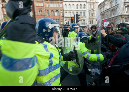 La polizia di tumulto marcia indietro battendo i manifestanti con manganelli su Whitehall, giorno X manifestazione studentesca, Londra, Inghilterra Foto Stock