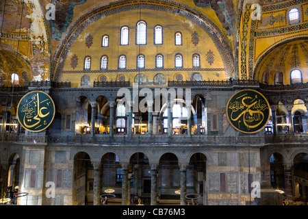 Turchia, Istanbul, Sultanahmet, Haghia Sophia Sightseeing turisti in galleria del Nord con coranici calligrafica islamica roundels Foto Stock