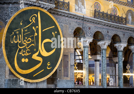 Turchia, Istanbul, Sultanahmet, Haghia Sophia Sightseeing di turisti nel nord galleria con coranici calligrafica islamica roundel Foto Stock