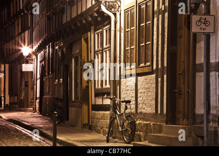 Una stretta strada di ciottoli di le case con la struttura in legno e una bicicletta di notte a Quedlinburg, Germania. Versione Mono disponibili: CB767T Foto Stock