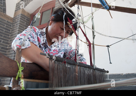 Una donna lavora su un vecchio telaio, Zhujiayu, Zhangqiu District, Shandong, Cina Foto Stock