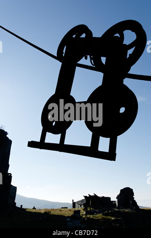 Una silhouette di un ingranaggio di sollevamento in una cava in disuso Foto Stock