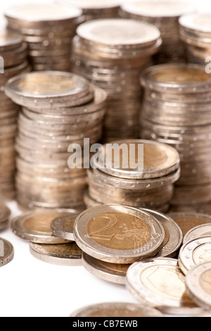 Close-up di pile di 2 Euro monete di fronte a uno sfondo bianco Foto Stock