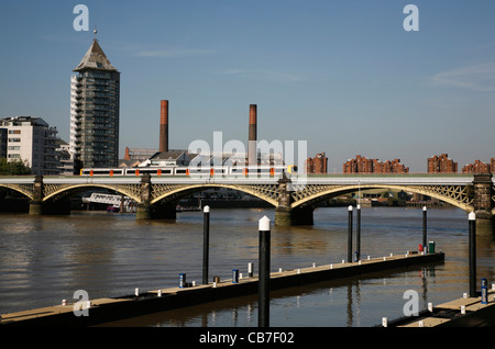 Overground treno che passa sopra il fiume Tamigi a Cremorne ponte ferroviario nei pressi di Chelsea Harbour, London, Regno Unito Foto Stock