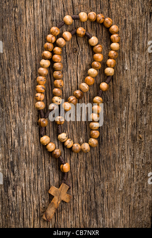 Rosario in legno talloni sul vecchio sfondo di legno Foto Stock