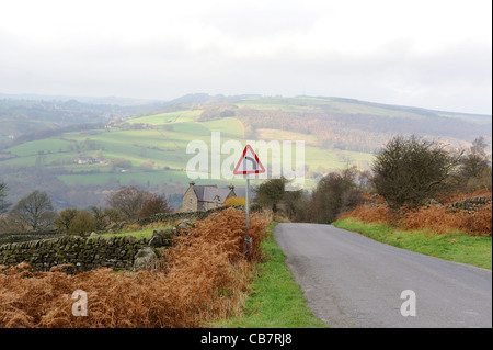 Autunno scena stradale con curva a sinistra segno curbar derbyshire Peak District Inghilterra Regno Unito Foto Stock