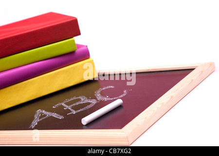 ABC lettere scritte su una lavagna con colorati libri (messa a fuoco selettiva) Foto Stock