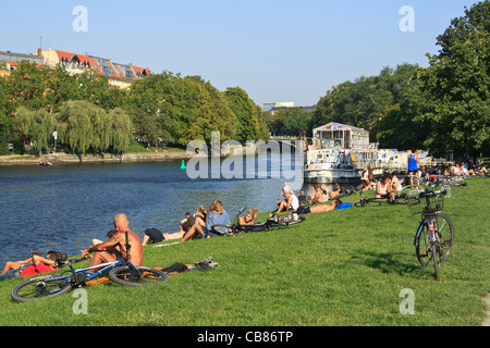 La gente di relax presso il fiume Sprea, banca. Quartiere Kreuzberg di Berlino, Germania. Foto Stock