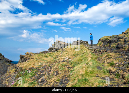 Una giovane ragazza in piedi sulla scogliera sopra il porto presso il villaggio Boscastle nel North Cornwall, England, Regno Unito Foto Stock