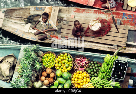 Fiume Niger delta, Bendel Membro, Nigeria. I ragazzi vendono frutta e birra da canoe a Bennett isola l'ancoraggio sul canale di Warri Foto Stock