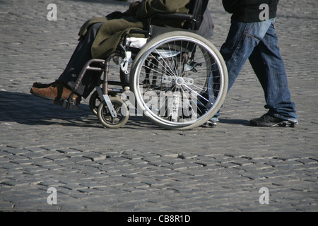 Dettaglio del vecchio uomo in sedia a rotelle in strada Foto Stock