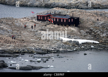 I turisti e i pinguini presso la casa di Bransfield, ex base britannica a Port Lockroy, Antartide Foto Stock