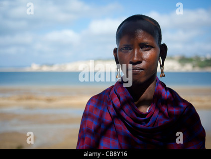 Uomo Masai Keeper con la testa rasata e abiti tradizionali con il mare in background, Lamu, Kenya Foto Stock