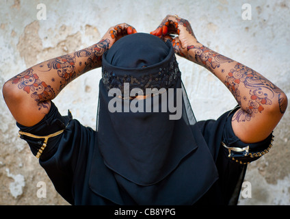 Irriconoscibile giovane donna indossa Hijab velo mostra il palmo della Sua mano dipinta con Henna e blu indaco, Lamu, Kenya Foto Stock