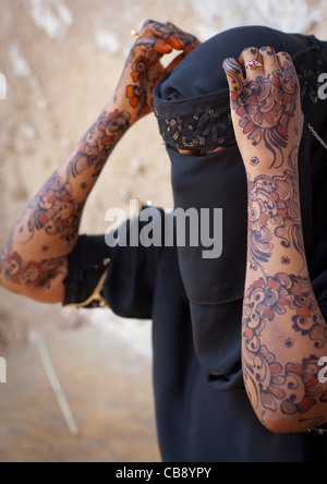 Irriconoscibile giovane donna indossa Hijab velo mostra il palmo della Sua mano dipinta con Henna e blu indaco, Lamu, Kenya Foto Stock