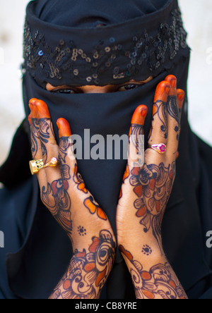 Irriconoscibile giovane donna indossa Hijab velo mostra il palmo della Sua mano dipinta con Henna e blu indaco, Lamu, Kenya Foto Stock