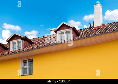 Bel giallo vecchia casa con blu cielo nuvoloso in background (Tallinn, Estonia, Europa) Foto Stock