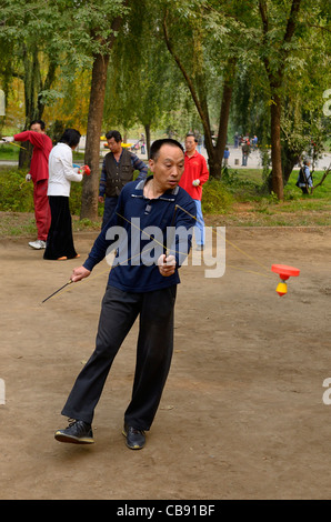 L'uomo la filatura di un cinese yo yo in zizhuyuan Purple Bamboo Park di Pechino repubblica popolare cinese Foto Stock