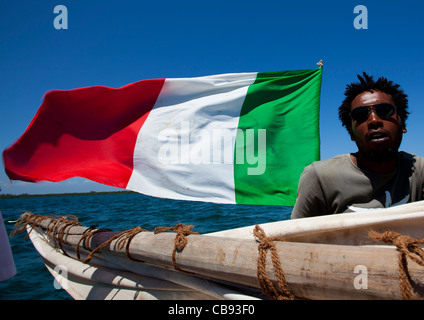 Un uomo con la bandiera italiana e gli occhiali da sole su un dhow vicino a Lamu Costa, Kenya Foto Stock