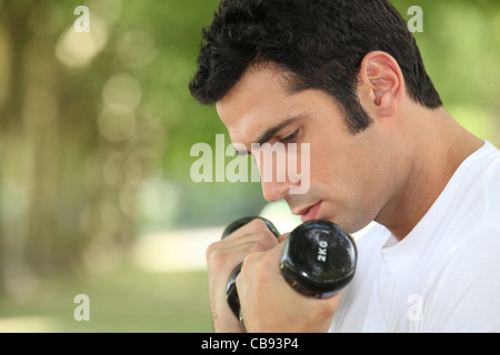 L'uomo utilizzando i pesi a mano Foto Stock