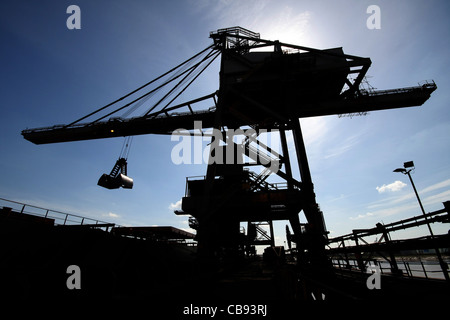 Dockside gru di scarico in silhouette. Foto Stock