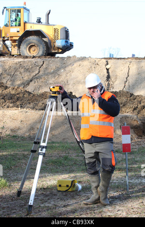 Un ingegnere matura prendendo misure in loco. Foto Stock