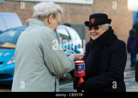 Signora anziana per raccogliere per l'Esercito della salvezza nella corsa al Natale Foto Stock