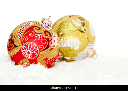 Rosso e oro palle di Natale sulla neve su bianco Foto Stock