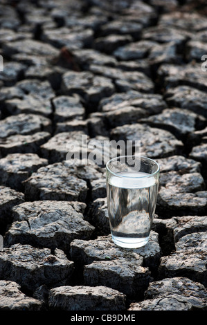 Bicchiere di acqua sul secco massa rotto. India Foto Stock