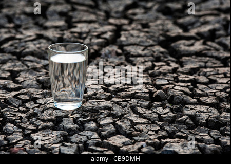 Bicchiere di acqua sul secco massa rotto. India Foto Stock