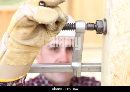 Uomo con morsa per proteggere il legno Foto Stock