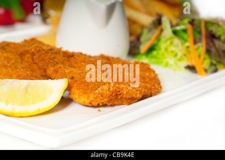 Panato classica cotoletta di vitello alla milanese con patatine fritte e verdure su sfondo ,più cibo delizioso sul portafoglio Foto Stock