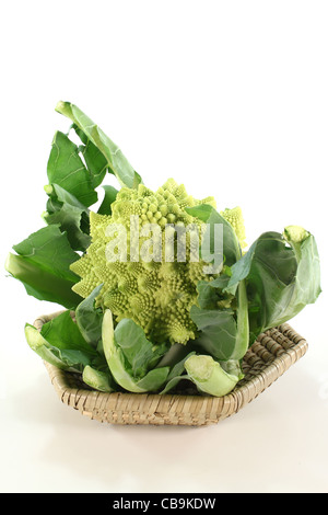 Romanesco fresche verdure in un cesto su sfondo bianco Foto Stock