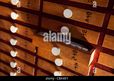 Cassetti contenenti fortune-telling pieghevoli, noto come omikuji, presso il Tempio di Senso-ji, nel quartiere di Asakusa di Tokyo, Giappone. Foto Stock