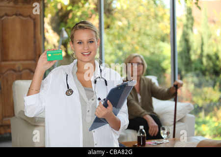 Un infermiere visitando un paziente anziano a casa Foto Stock