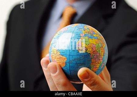 Imprenditore tenendo un globo in mano, vicino. Foto Stock