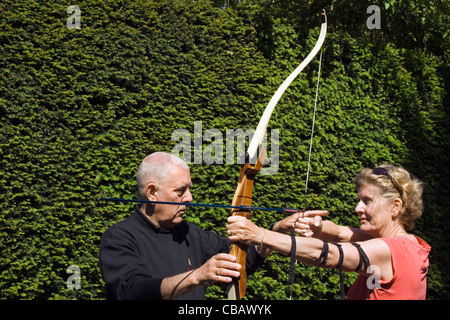 Donna ricevere lezioni di tiro con l'arco. Foto Stock