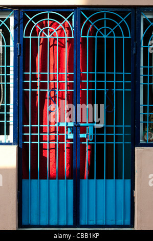 Blu colorato villaggio indiano gated house con tende rosse. Andhra Pradesh. India Foto Stock