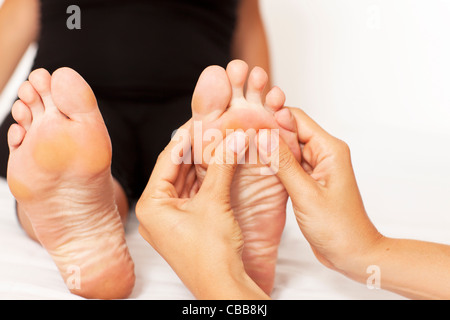 Le mani umane massaggiare una donna di piedi Foto Stock