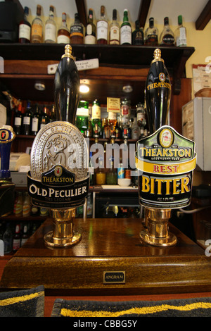 Theakstons Old peculiare e Best Bitter handpumps in un tradizionale Yorkshire Dales country pub Foto Stock