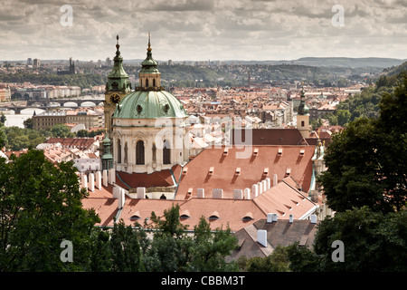 La mattina presto vista della Cattedrale di San Nicola e sui tetti della bellissima città barocca di Praga. Foto Stock