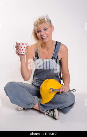Fotografia di una donna con un casco di sicurezza e chiave prendendo una pausa Foto Stock
