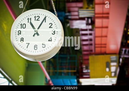 Grande Orologio che pendono dal soffitto in fabbrica Foto Stock