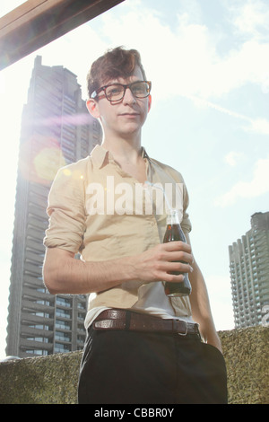 Uomo di bere soda sul balcone Foto Stock