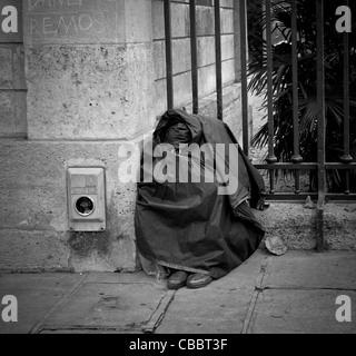 I senzatetto a forma di sacco il giardino di piante., dormire seduto, come un fantasma. Foto Stock